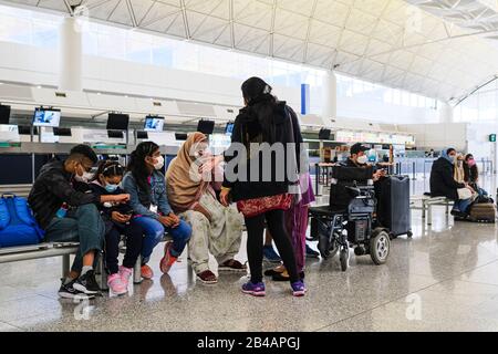 Hong Kong, China. 06th Mar, 2020. A Family wearing face masks as a precaution against the outbreak of Coronavirus wait at the departure hall in Hong Kong International Airport.As the Coronavirus (Covid-19) continues to spread all over the world, many countries have tighten up travel restrictions. Credit: SOPA Images Limited/Alamy Live News Stock Photo