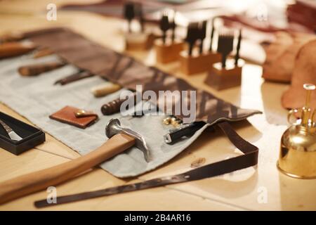 Horizontal high angle no people shot of various tools for professional leather craftwork on wooden table Stock Photo