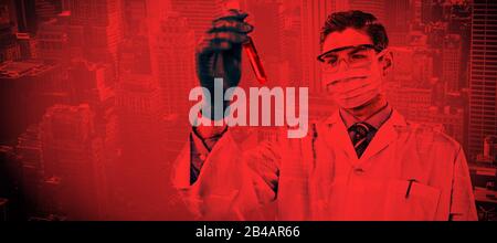 Composite image of doctor wearing protective glasses and surgical mask holding a test tube. Testing Stock Photo