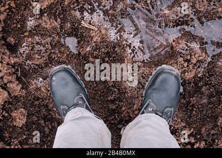 Black work boots on ice covered ground. Work shoes for work. Stock Photo
