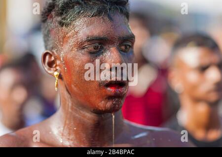 Malaysia, Selangor State, Batu Caves, Hindu festival Thaipusam procession, celebration of god Murugan, son of Shiva and Parvati, exhausted pilgrim with water dripping on his face Stock Photo