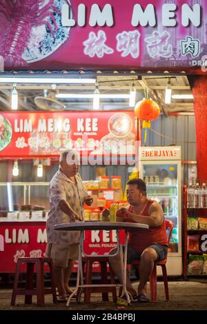 Malaysia, Kuala Lumpur Federal Territory, Kuala Lumpur, Jalan Alor Night Food Court, customers sitting in the street at night, in front of a restaurant Stock Photo