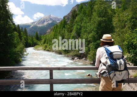 France, Alpes de Haute Provence, Ubaye, Saint Paul sur Ubaye, Female hiker on a bridge crossing the Ubaye river Stock Photo