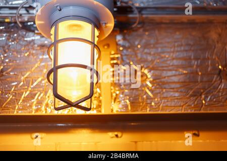 Industrial explosion-proof lantern of black and gray shines with white light at coal mining exhibition Stock Photo