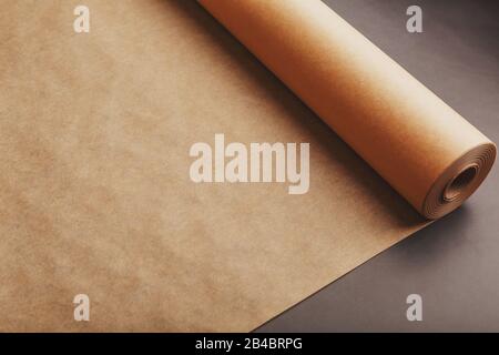 Vintage paper unfolded from a roll on a dark background. Papyrus, parchment, soft contrast Stock Photo