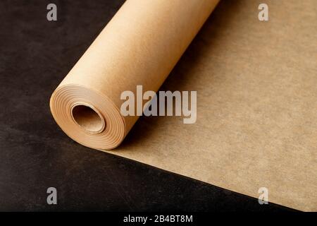 Parchment paper as the background, deployed from a roll. For baking food on dark background, top view. Papyrus Stock Photo