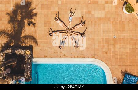Vertical top view of group of women young friends compose a star together with their bodies - concept of summer people vacation lifestyle and friendship together - beautiful background hotel pool Stock Photo