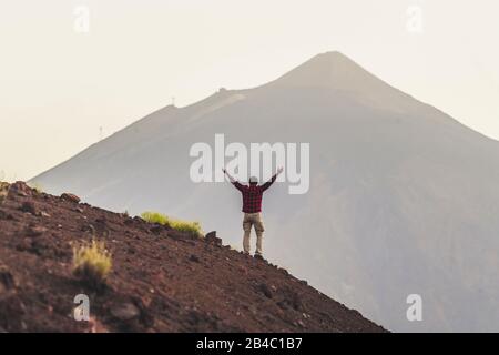 Hiker, people, man standing in front of a high mountain in background - concept of travel and success destination - outdoor leisure activity lifestyle for active adult in the wild free nature Stock Photo
