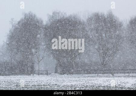 Snowflakes falling on an already snow covered field Stock Photo