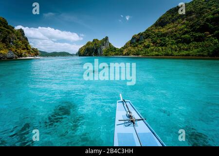 Boat trip to tropical islands El Nido, Palawan, Philippines. Steep green mountains and blue water lagoon. Discover exploring unique nature, journey to paradise. Stock Photo