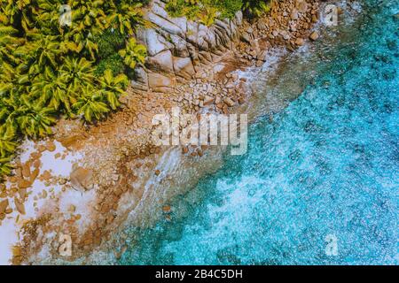 Aerial drone helicopter view of crystal clear turquoise water and amazing granite rocks. La Digue Island Seychelles. Stock Photo