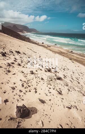 Praia Grande. Spectacular sand dunes, ocean waves and black volcanic stones. Barren landscape of Calhau, Sao Vicente Island Cape Verde. Stock Photo