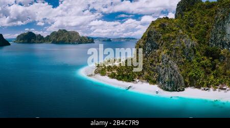 El Nido, Palawan, Philippines. Aerial drone shot of Ipil beach located on Pinagbuyutan Island. Amazing white sand, coconut palm trees and turquoise blue ocean water. Stock Photo