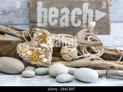 Beach still life with sign, shell heart, driftwood and pebble Stock Photo