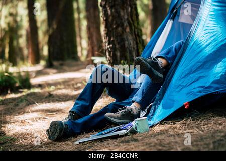 Unrecognizable couple in outdoor leisure  activity inside a tent in the forest- concept of alternative travel and enjoy nature lifestyle together withlove and relationship Stock Photo