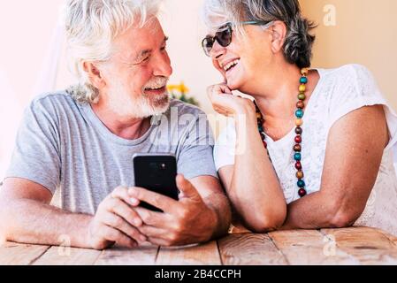 Couple of old happy cheerful people caucasian senior man and woman smiling together each other with love - concept of forever together life - joyful for aged family Stock Photo