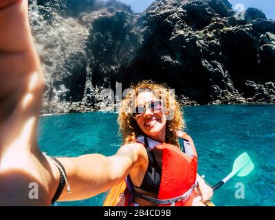 Cheerful people happy smiling female take selfie picture with kayak having outdoor leisure sport activity in the blue ocean water - concept of hapiness in summer holiday vacation Stock Photo