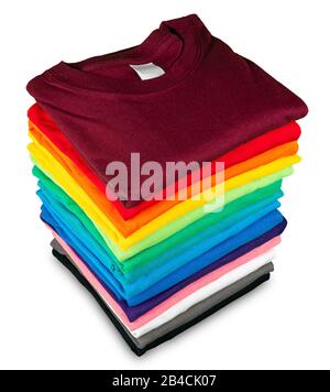 Stack of many fresh new fabric cotton t-shirts in colorful rainbow colors isolated. Pile of various colored shirts on white background Stock Photo