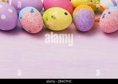 Easter eggs of various colors at the top of the table. Festive background with copy space Stock Photo