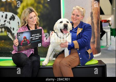 Cat Henstridge, TV personality and vet and Sussie Wiles (right), Kennel Club Assured Labrador breeder attend Crufts at the NEC Arena in Birmingham while supporting Defra's 'Petfished' campaign, which highlights how the public can be deceived by pet sellers before buying a new puppy or kitten and advises how to research and spot red flags. PA Photo. Picture date: Friday March 6th, 2020. On Monday April 6th 2020, the government's ban on third party sales of puppies and kittens comes into force. Known as 'Lucy's Law', it will help to end the terrible welfare conditions found in Stock Photo