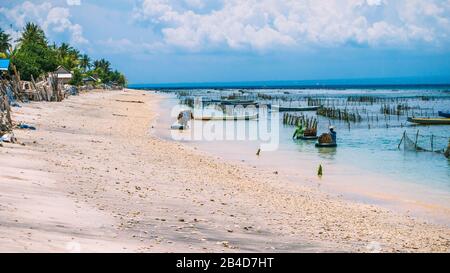 Seaweed plantation farm by Low Tide in Nusa Penida, Bali in Clouds on Background. Indonesia Stock Photo