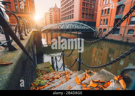 Speicherstadt, warehouse district in Hamburg, Germany, old brick buildings and canal in Hafencity on an autumn evening with sunset Stock Photo