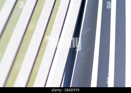 The close-up of the white painted cross struts of a bridge railing, which casts symmetrical shadows. , , Stock Photo