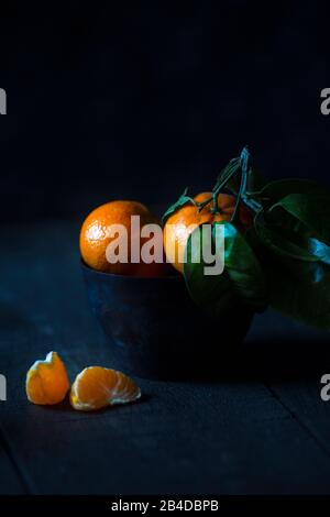 Mandarins on a dark background in a cup Stock Photo