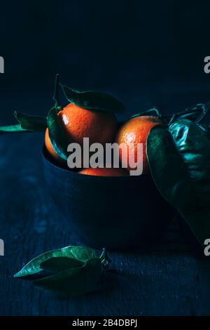 Mandarins on a dark background in a cup Stock Photo