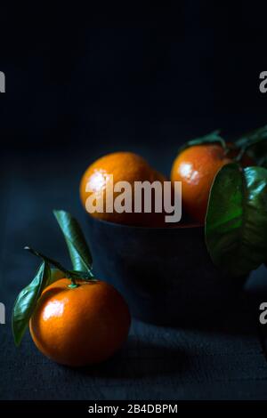 Mandarins on a dark background in a cup Stock Photo