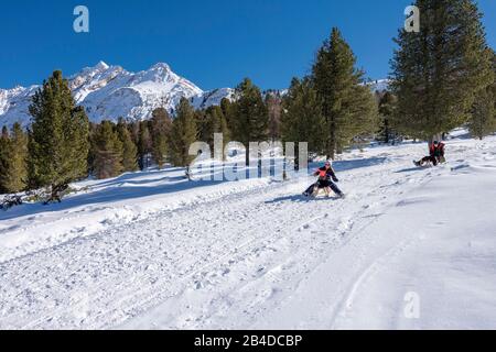 St. Vigil in Enneberg, Fanes, Dolomites, Province of Bolzano, South Tyrol, Italy, Europe. Two children on a toboggan ride below the Faneshütte Stock Photo