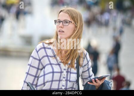 A tourist young woman looking for orientation in Syntagma Square, Athens, Greece Stock Photo