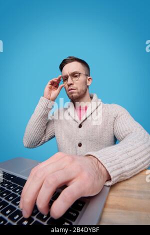 Hand of young serious businessman on laptop keypad during online search for information necessary for new business project Stock Photo