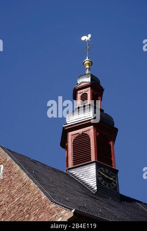 The clock tower and the steeple of the catholic church St. Martin in Eddersheim in the sunlight. Stock Photo