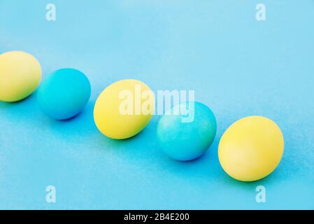 Easter blue and yellow eggs on blue background. Greeting Easter Spring Card Stock Photo
