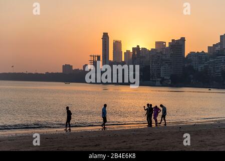 India, Maharashtra, Mumbai, People on Chowpatty Beach, Sunset, Skyline, Stock Photo