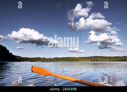 Rowboat tour through the Northuckar Lake landscape. The low sun shines on a helm, the lake is calm, a few nice clouds Stock Photo