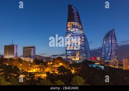 Azerbaijan, Baku, Flame Towers with mosque, dusk Stock Photo