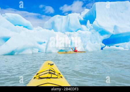 Kayaker paddles among icebergs, Torres del Paine National Park, Patagonia, Chile, South America Stock Photo