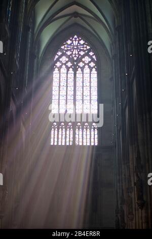 Light rays falling through colored stained glass windows in the Cologne Cathedral, The judge window, modern Südquerhausfenster by Gerhard Richter with pixel-like color squares, Cologne, North Rhine-Westphalia, Germany Stock Photo