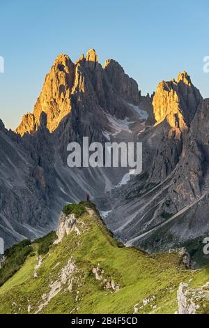Monte Campedelle, Misurina, Auronzo di Cadore, Provinz von Belluno, Venetien, Italien, Europa. Ein Bergsteiger bewundert den Sonnenaufgang in der Cadi Stock Photo
