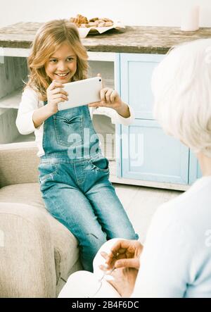 Beautiful Young Girl Making Photo Or Video Of Her Grandmother Stock Photo