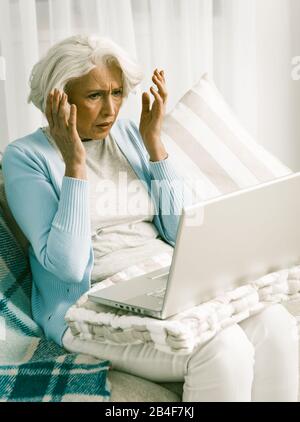 Frustrated Senior Woman Having Difficulty Using Laptop Computer Stock Photo