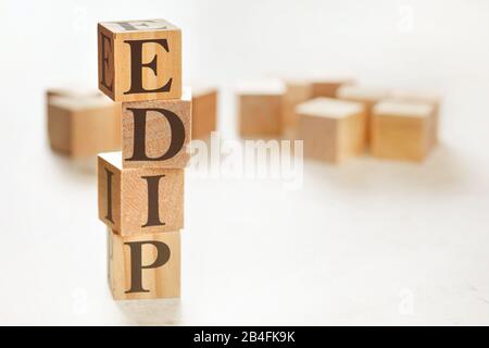 Four wooden cubes arranged in stack with letters EDIP meaning Explain, demonstrate, imitate, practice on them, space for text image at down right corn Stock Photo