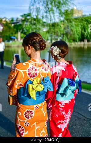 Young women wearing traditional Japanese dress at Sarasawa-ike Pond, Nara, Honshu, Japan Stock Photo