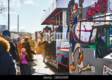 Europe, Switzerland, Basel, traditional event, Basel Fasnacht, the largest in Switzerland, intangible cultural heritage of humanity, Cortège at the Wettsteinplatz, theme car with subject 'Frauenquote', confetti rain Stock Photo