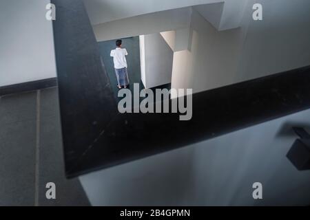 winding stairwell in dark mood with a person on lower level Stock Photo