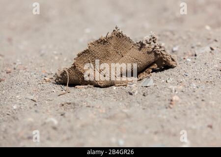 Fragments of cloth and remains from past civilizations laying on the desert sand in the archeological site of Pachacamac, Peru. Stock Photo