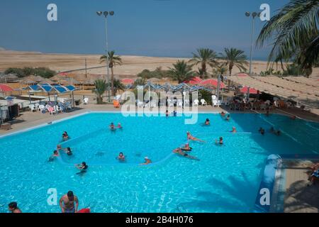 Swimming pool with Dead Sea in background in En Gedi oasis, Israel. Ein Gedi , literally 'spring of the kid (young goa' is an oasis and a nature reserve in Israel, located west of the Dead Sea, near Masada and the Qumran Caves. Ein Gedi was listed in 2016 as one of the most popular nature sites in the country Stock Photo