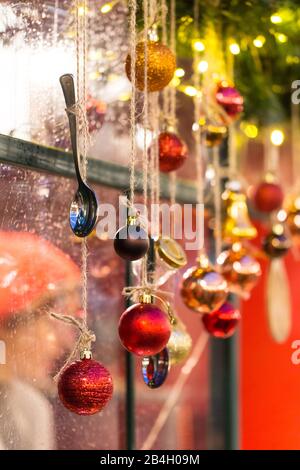 Christmas Fair, close up of teaspoon and balls decorations in the shop, soft focus. Winter street market in Europe Stock Photo